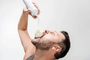 depositphotos_256076952-stock-photo-chubby-man-spraying-whipped-cream.webp