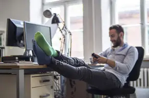 focused_179896296-stock-photo-young-man-office-feet-desk.webp